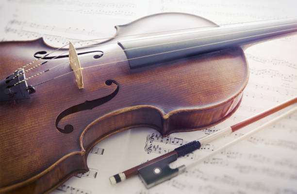 Violin Still life Close up view of brown violin lying on music score sheets violin photos stock pictures, royalty-free photos & images