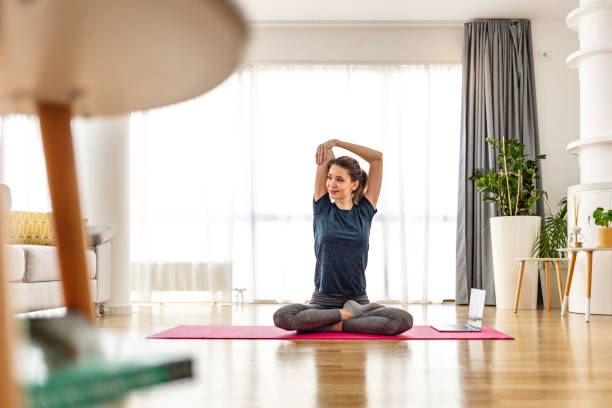 Building a stronger core Attractive young woman doing yoga stretching yoga online at home. Self-isolation is beneficial, entertainment and education on the Internet. Healthy lifestyle concept. mat photos stock pictures, royalty-free photos & images