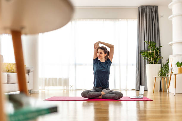 building a stronger core - stretching women attractive female indoors imagens e fotografias de stock