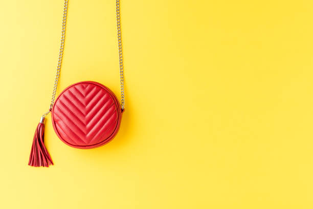 istock Red woman’s purse on yellow background with copyspace. Flat lay 1268037143