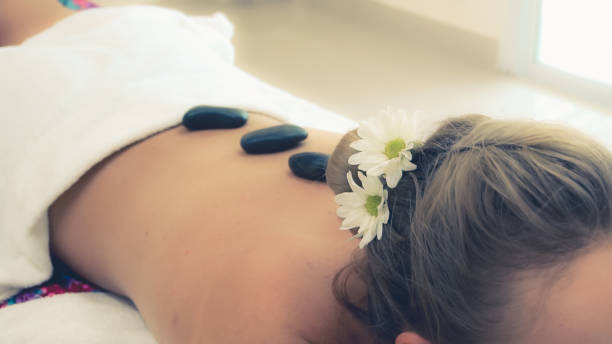 istock Hot stone massage treatment by therapist in spa. 1268037181
