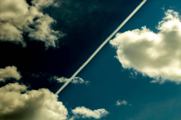 The  with  is divided by an airplane trail, distorted by dramatic deep blues. Concept of environmental problems and weather anomalies, weather forecast. Place for text, copy space.