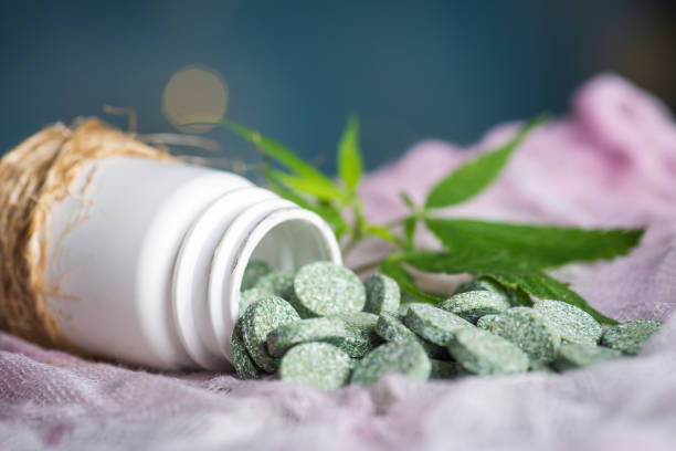 pilules de comprimés médicaux avec le cannabis et la feuille de marijuana - pill medicine laboratory narcotic photos et images de collection