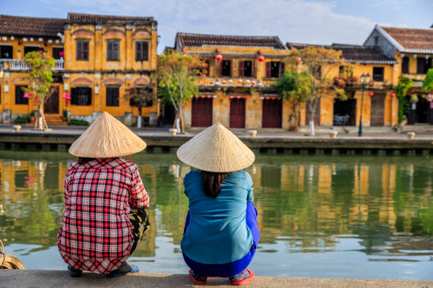 Vietnamese women looking at old town in Hoi An city, Vietnam Vietnamese women looking at old town in Hoi An city, Vietnam. Hoi An is situated on the east coast of Vietnam. Its old town is a UNESCO World Heritage Site because of its historical buildings. hoi an stock pictures, royalty-free photos & images