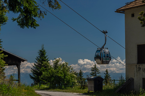 Cable car Kanzelhohe in green needles forest in summer sunny day in Austria