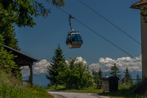 Cable car Kanzelhohe in green needles forest in summer sunny day in Austria