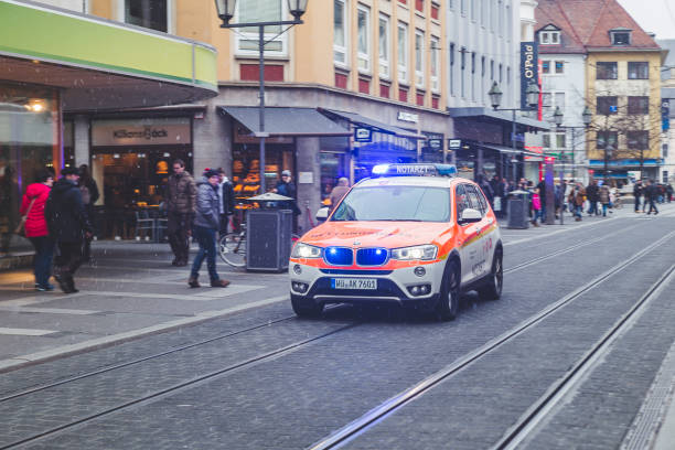 une voiture de service médical d’urgence conduisant sur un appel dans une rue à wurzburg, allemagne - ambulance healthcare and medicine germany car photos et images de collection