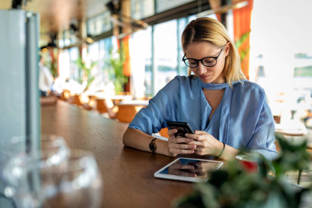 istock An Attractive Blonde Woman is Using her Mobile Phone for Online Browsing while Sitting in the Modern Café. 1268047596