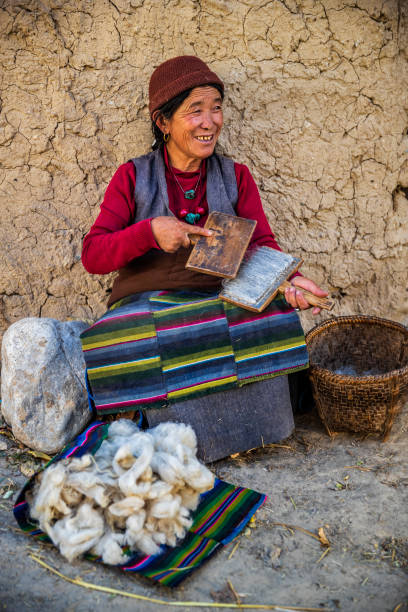 istock Tibetan woman combing wool in Upper Mustang, Nepal 1268049321