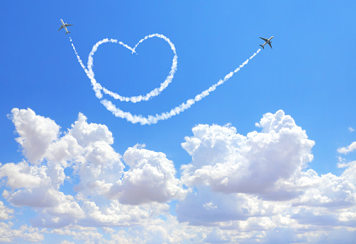 Two aircrafts draw a heart in the sky. Flight route of aircraft in shape of a heart. Love concept for traveling the world
