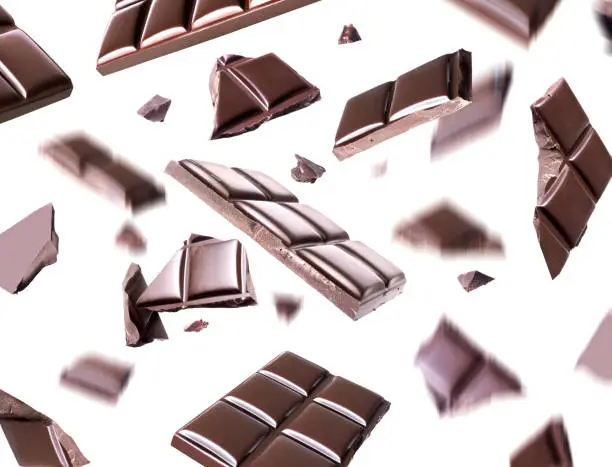 Broken chocolate bars in the air on a white background