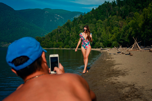 a man photographs a girl on the beach