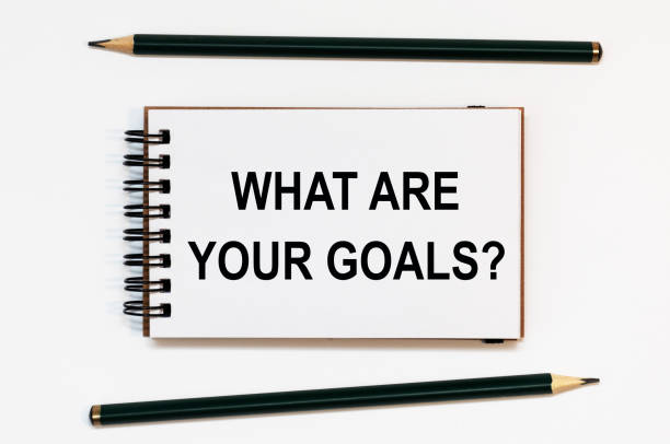 istock WHITE SPIRAL NOTEBOOK, TWO PENCILS WITH TEXT WHAT ARE YOUR GOALS 1268056666