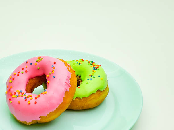 istock donuts pink and green on a blue plate closeup 1268056838
