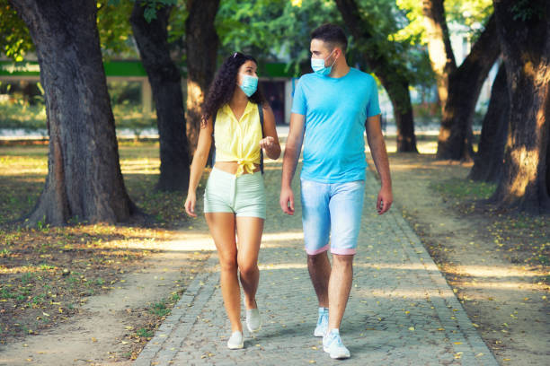 istock Couple wearing face masks walking in the park 1268057921