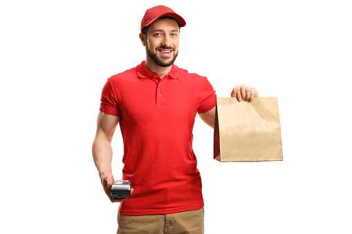 Food delivery guy holding a paper bag and a credit card terminal isolated on white background