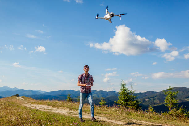 istock Drone video shooting of summer Carpathins. Man operating copter controller in mountains. Tourist filming nature 1268066487