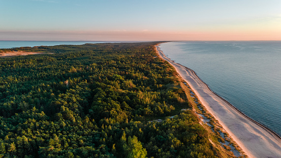 Hermoso paisaje de Curlandia escupir en el mar Báltico con bosque, playa y mar al atardecer. disparo aéreo desde drone photo