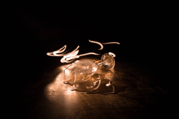 istock Broken glasses on wooden table at dark toned background with fog. Selective focus 1268069299