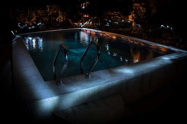 istock Pool and waterfall at night - vacation background. Colorful light decoration. Freezelight 1268069303