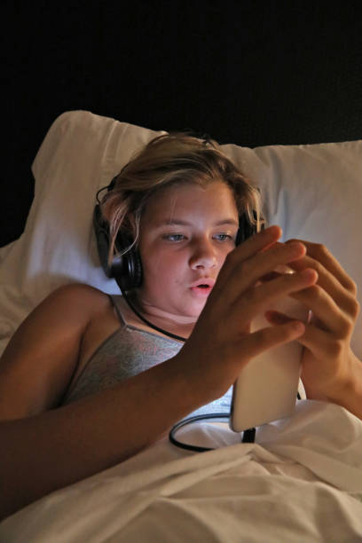 istock Caucasian girl lying on the bed and using her phone. 1268069534