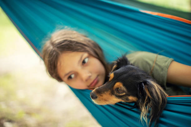 istock Girl relaxing in hammock with her dog 1268074720