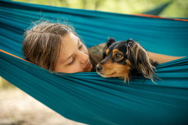 istock Girl relaxing in hammock with her dog 1268074754