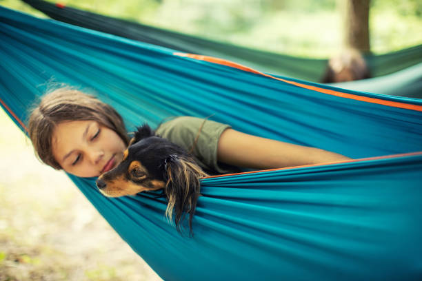 istock Girl relaxing in hammock with her dog 1268074767