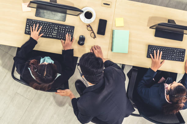 istock Business people wearing headset from top view in office working with computer 1268077559