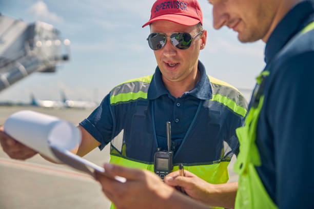 istock Two focused airport workers scrutinizing after-landing checklists 1268078267