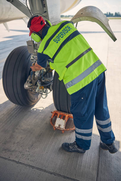 istock Airport worker examining the landing gear system 1268078284