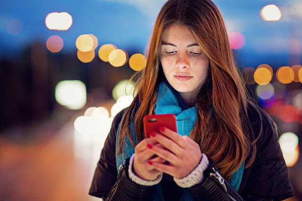 istock Young girl is texting on the bridge at night 1268081965