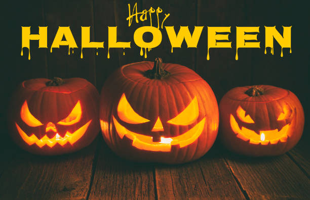 istock Pumpkins carved for Halloween on Rough Wood Table. 1268084342