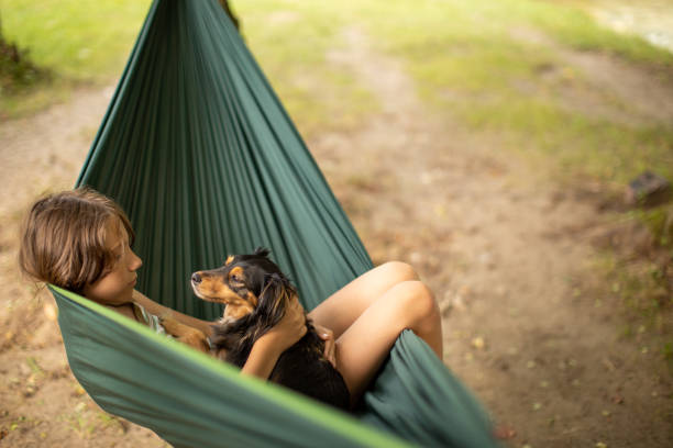 istock Boy relaxing in hammock with her dog 1268084345