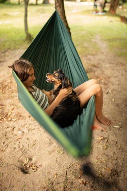 istock Boy relaxing in hammock with her dog 1268084408