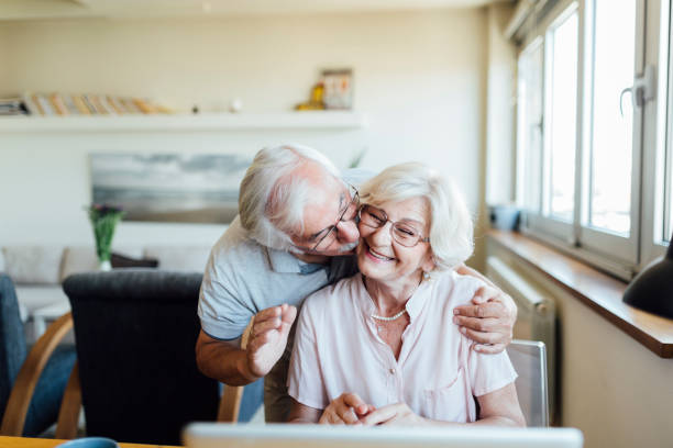 istock Happy elderly couple having a video call on a laptop 1268086733