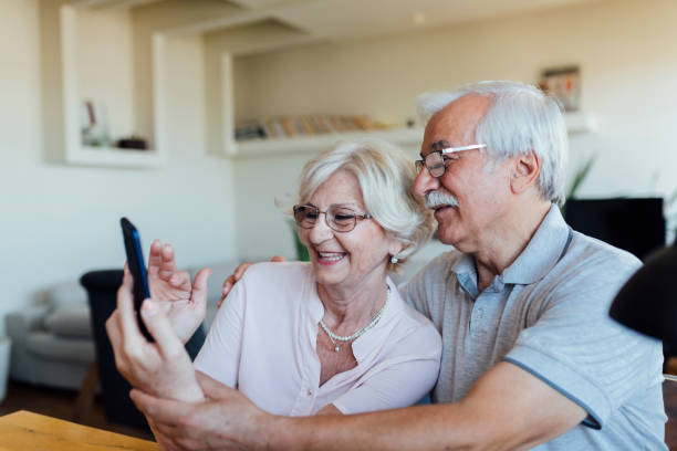 istock Happy elderly lovers using a smart phone at home 1268086767