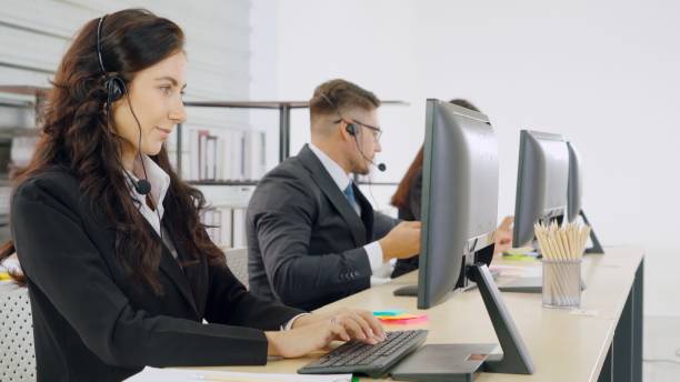 istock Business people wearing headset working in office 1268089697