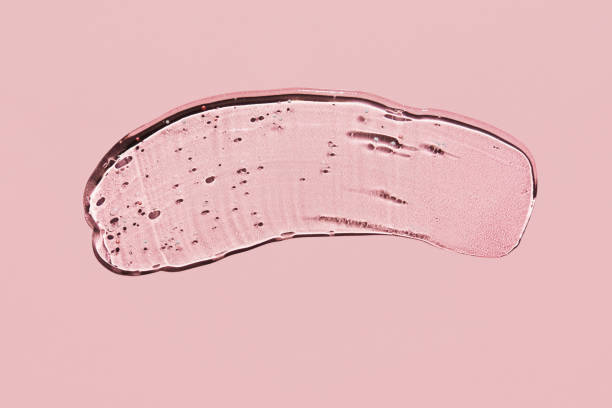 istock Transparent liquid gel on pink background. Textured smear with oxygen bubbles 1268120193
