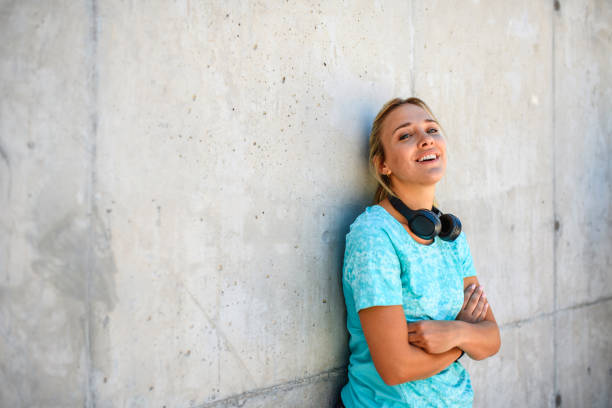 istock Relaxed Female Athlete Leaning Head Against Cement Wall 1268120707