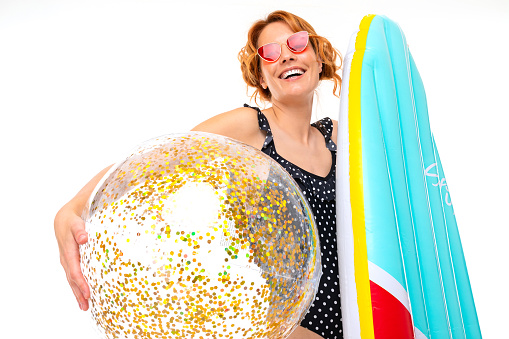 beach party concept, cute girl holding a surfboard and ball with sparkles on a white background.