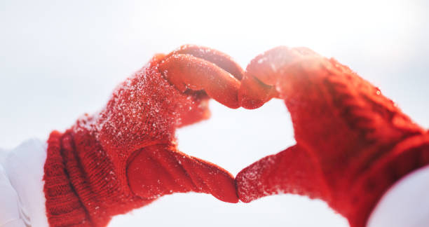 istock Woman making heart symbol with snowy hands 1268120801