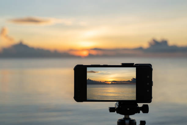istock Smartphone capturing beach sunrise over the sea or ocean with clouds. 1268124643