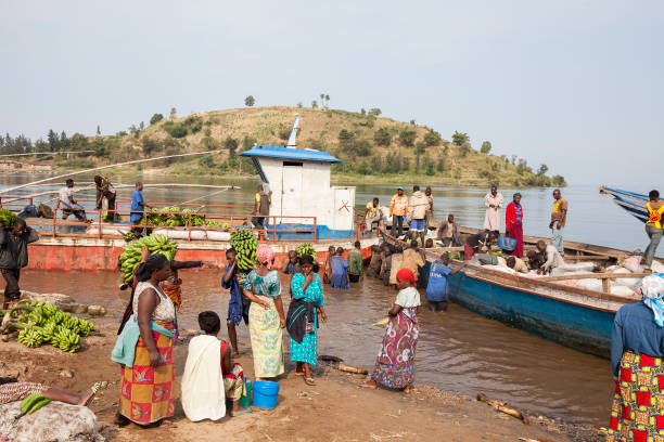 Market along lake Kivu in Rwanda Rwanda, Lake Kivu- May 2017:  People carrying bananas. Crowded market along lake Kivu, where vendors arrive by boat from Democratic Republic of the Congo and sell fruits. lake kivu stock pictures, royalty-free photos & images