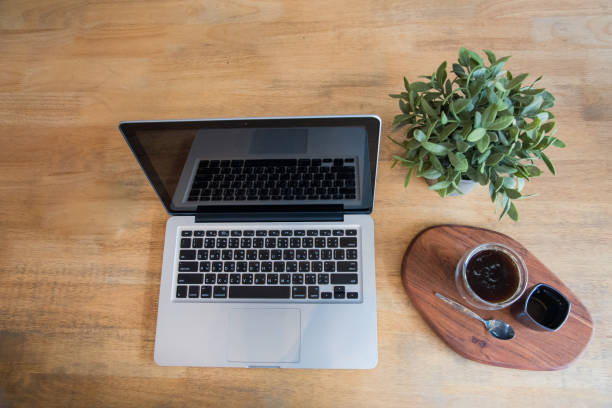 istock Office laptop business financial document chart and graph on wooden table with coffee cup. Flat lay notebook computer laptop on office desk. No people business graph chart mockup on business workspace 1268143002