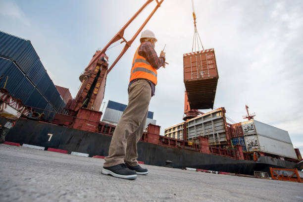 man asiático trabajador de carga de la radio trabajador de contenedores hablando en el walkie-talkie en el almacén de contenedores. - freight transportation audio fotografías e imágenes de stock