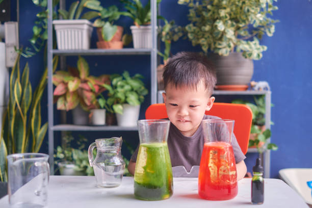 istock Asian school kid studying science, making DIY Lava Lamp Science Experiment, Kid-friendly fun and easy science experiments at home concept 1268145243