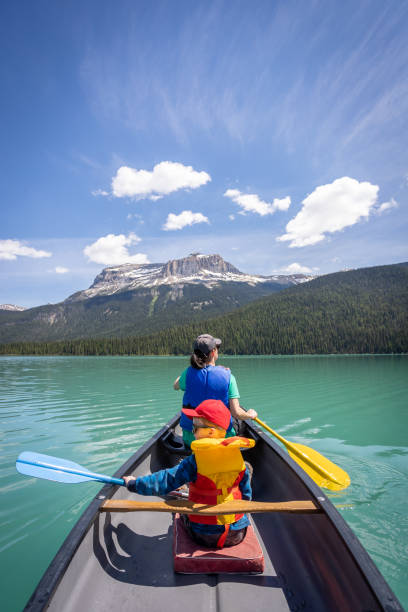 pov family canoeing at emerald lake in summer, yoho national park, colombie-britannique, canada - british columbia canada lake emerald lake photos et images de collection