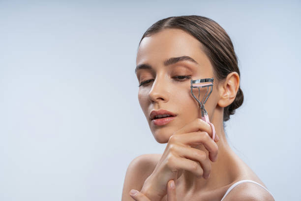 istock Calm female curling her eyelashes with an eyelash curler 1268148996