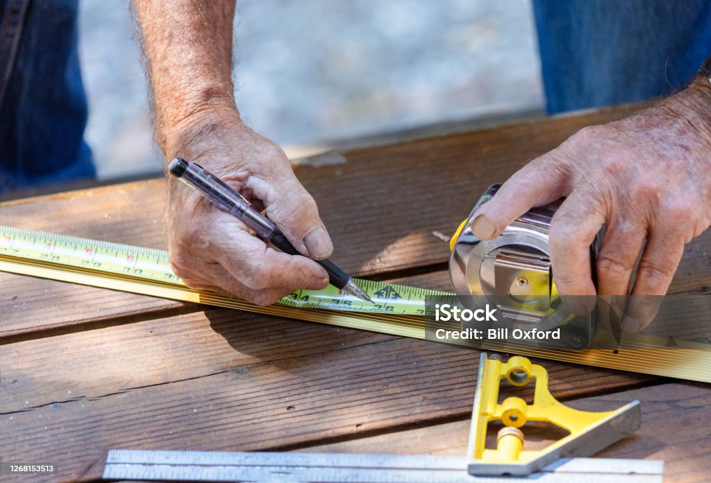 Carpinteiro medindo limiar de metal para corte - Foto de stock de Medindo royalty-free Carpinteiro medindo limiar de metal para corte - Foto de stock de Medindo royalty-free